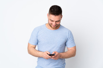 Russian handsome man over isolated background sending a message with the mobile