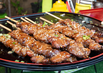 Beef cattle breed that has been grilled with charcoal stove Complete with a flavoring sauce, sprinkled with sesame seeds and sliced ​​spring onions. It was placed on a plate ready for sale.