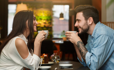 Young Lovers Enjoying Coffee Together In Cafe, Side View