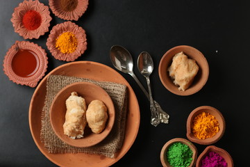 Fototapeta na wymiar Dahi vada is Indian chaat Fast food of india popular for Holi. served in earthen bowl. Holi food concept