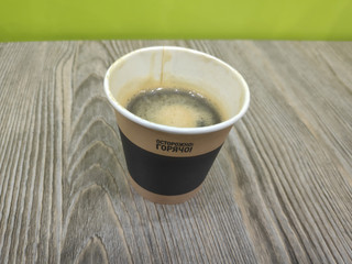 Coffee in a paper cup. On a wooden table. The inscription translated from Russian means: Caution is...