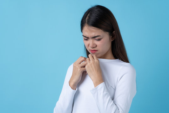 Woman smelling bad from her shirt because dirty laundry.