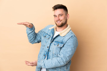 Russian handsome man over isolated background holding copyspace to insert an ad