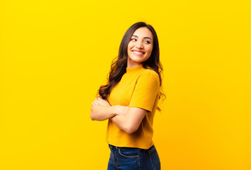 young latin pretty woman smiling gleefully, feeling happy, satisfied and relaxed, with crossed arms...