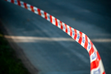 Red and white protection tape with "POLICJA" inscription. Polish police "do not cross" tape © diesirae