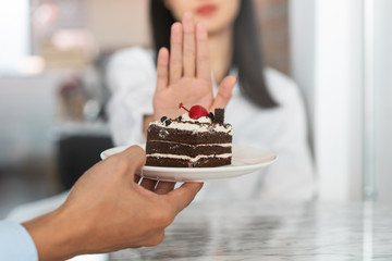 Say no to sweet during diet. Woman refusing to eat cake and push off.