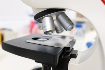 Close-up shot of microscope with metal lens at laboratory.  Chemistry and science research concept background.