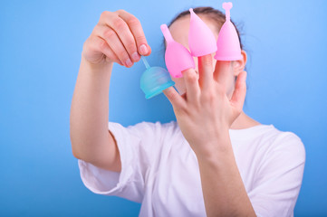 A shot of a menstrual cup of different sizes in the hands of a woman. Feminine and lifestyle. Young girl and modern hygiene products.