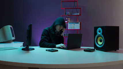 hacker in the hood near the computer