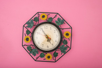 Close up clock set on pink background, time concept with copy space