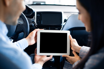 Couple Using Tablet With Empty Screen Sitting In Car, Back-View