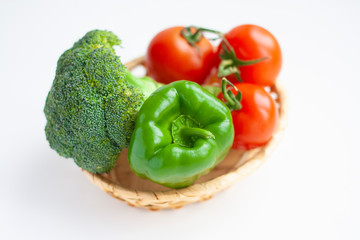 Broccoli, green bell peppers and tomatoes in a basket