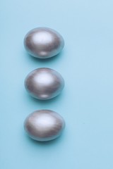Silver easter eggs on a blue background.