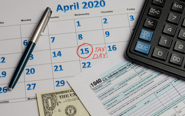 Naklejka na ściany i meble April 15 tax day calendar calculator and tax return form on the table
