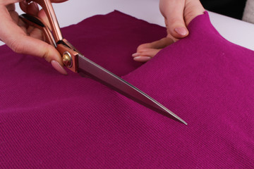 cutting fabric with scissors on a white background