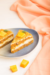 Homemade cake with persimmon and pumpkin on a white wooden background with orange textile. side view, selective focus.