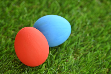 red and blue easter egg on lawn green grass artificial, concept image of morning in springtime