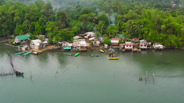 Old wooden house standing on the sea in the fishing village, aerial view. Houses community standing in water in fishing village. Luzon, Philippines.