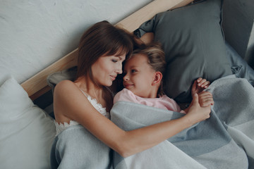 Obraz na płótnie Canvas Mother sleep hugging with little daughter girl. Family and mother's day concept.