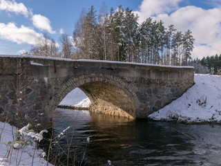 arched bridge over a fast flowing river