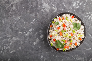 Pearl barley porridge with vegetables in blue ceramic bowl.  Top view, copy space.