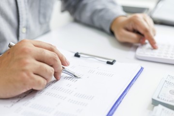 Businessman checking bills. taxes bank account balance and calculating annual financial statements of company. Accounting Audit Concept.