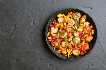 Grilled vegetables with sausages and herbs in frying pan