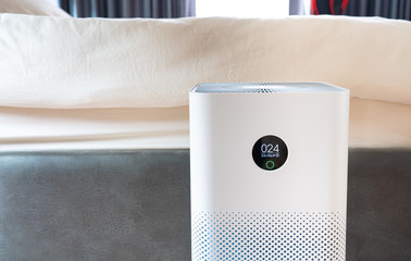 Indoor air purifier with digital monitor screen in bedroom, that show air quality in the room and air pollution levels in the room. PM 2.5 is a major environmental health problem affecting everyone.