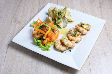 Garlic shrimp, bathed in garlic sauce, accompanied by potatoes and vegetables