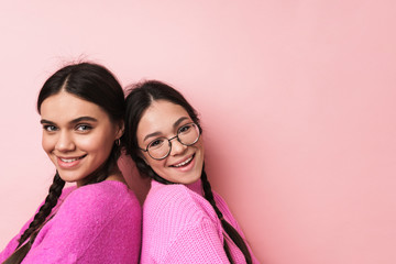 Image of two happy teenage girls in casual clothes smiling at camera