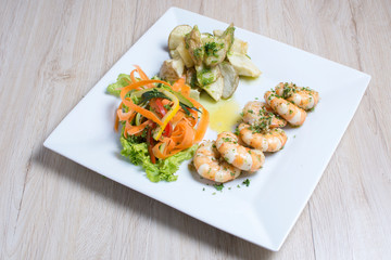 Garlic shrimp, bathed in garlic sauce, accompanied by potatoes and vegetables