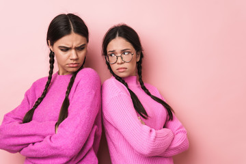 Image of two angry teenage girls standing back to back with arms crossed