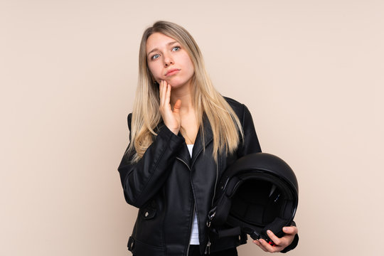 Young blonde woman with a motorcycle helmet over isolated background thinking an idea