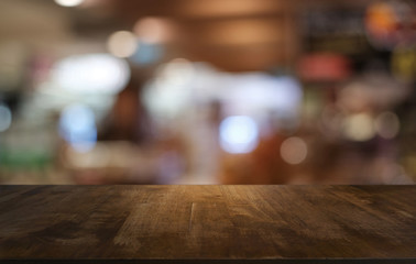 Empty dark wooden table in front of abstract blurred bokeh background of restaurant . can be used for display or montage your products.Mock up for space.