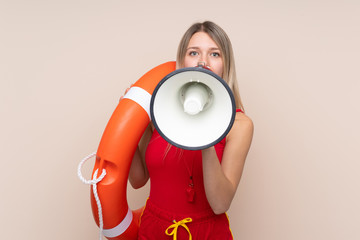 Lifeguard woman holding a megaphone over isolated background