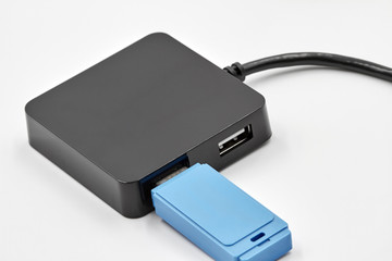 Black portable USB hub for four connections with usb flash drive on a white background. Bus...