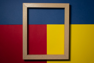 Wooden frame on a multi colored background. Space for copy-paste. Top view of a rectangular frame