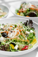 mixed fresh organic salads on white restaurant table