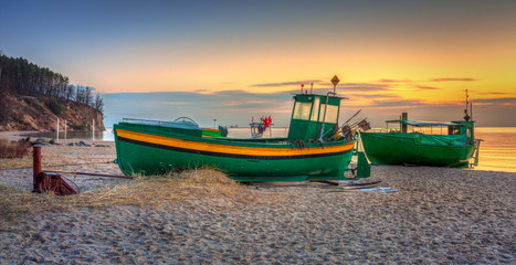 Fishing boats on the Baltic Sea beach at sunrise in Gdynia Orlowo, Poland