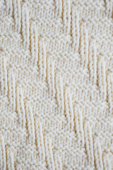 The texture of the fabric. White knitted pattern. background.
