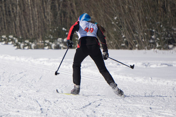 Young sexy blonde with skis. Mountain-skier.Studio. Brick background.