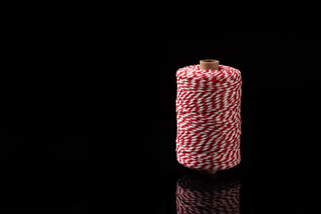 Conceptual image of a roll of rope on a black background, copy space background