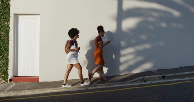 Two mixed race women walking on street