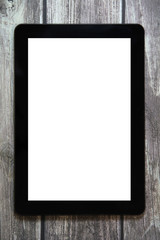 A tablet with a white blank screen lies on a background of wooden boards.
