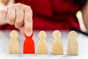 Figure in human resource management concept. The red wood figure was picked out of its group. Red Wood figure like who is selected from the candidate, or choose the most dominant in the team.