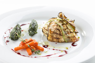 grilled vegetables eggplant, zucchini, baby carrot and spinach on white plate isolated on white background