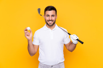 Golfer player man over isolated yellow background smiling a lot