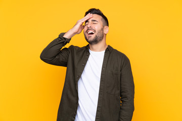 Naklejka premium Man over isolated yellow background laughing