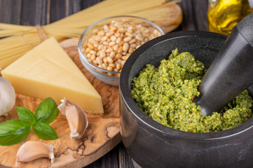Preparation of basil pesto sauce with the main ingredients: fresh basil leaves, parmesan cheese, pine nuts, garlic