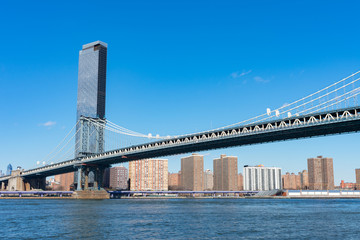 The Manhattan Bridge over the East River next to the Lower East Side New York City Skyline